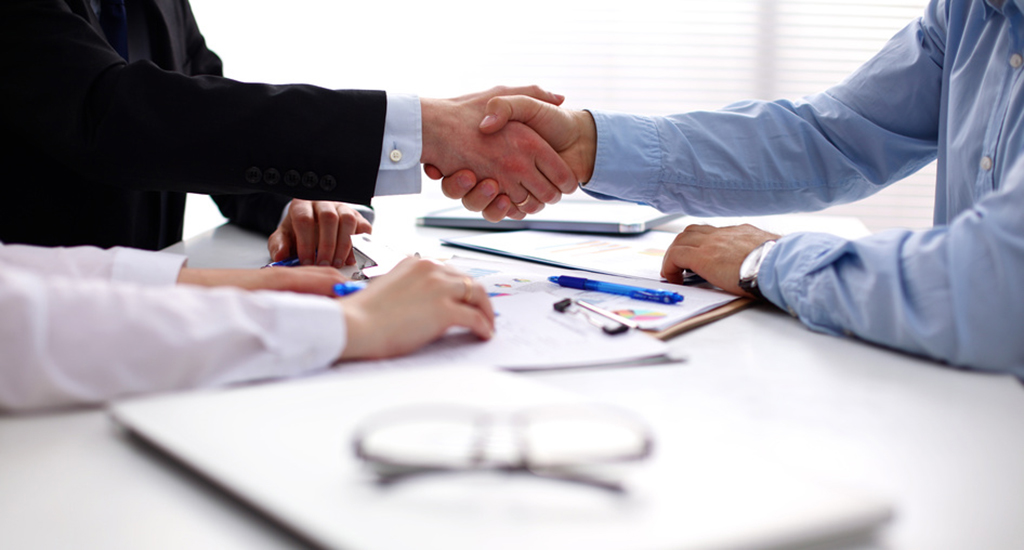 Business people handshake, sitting at the table.